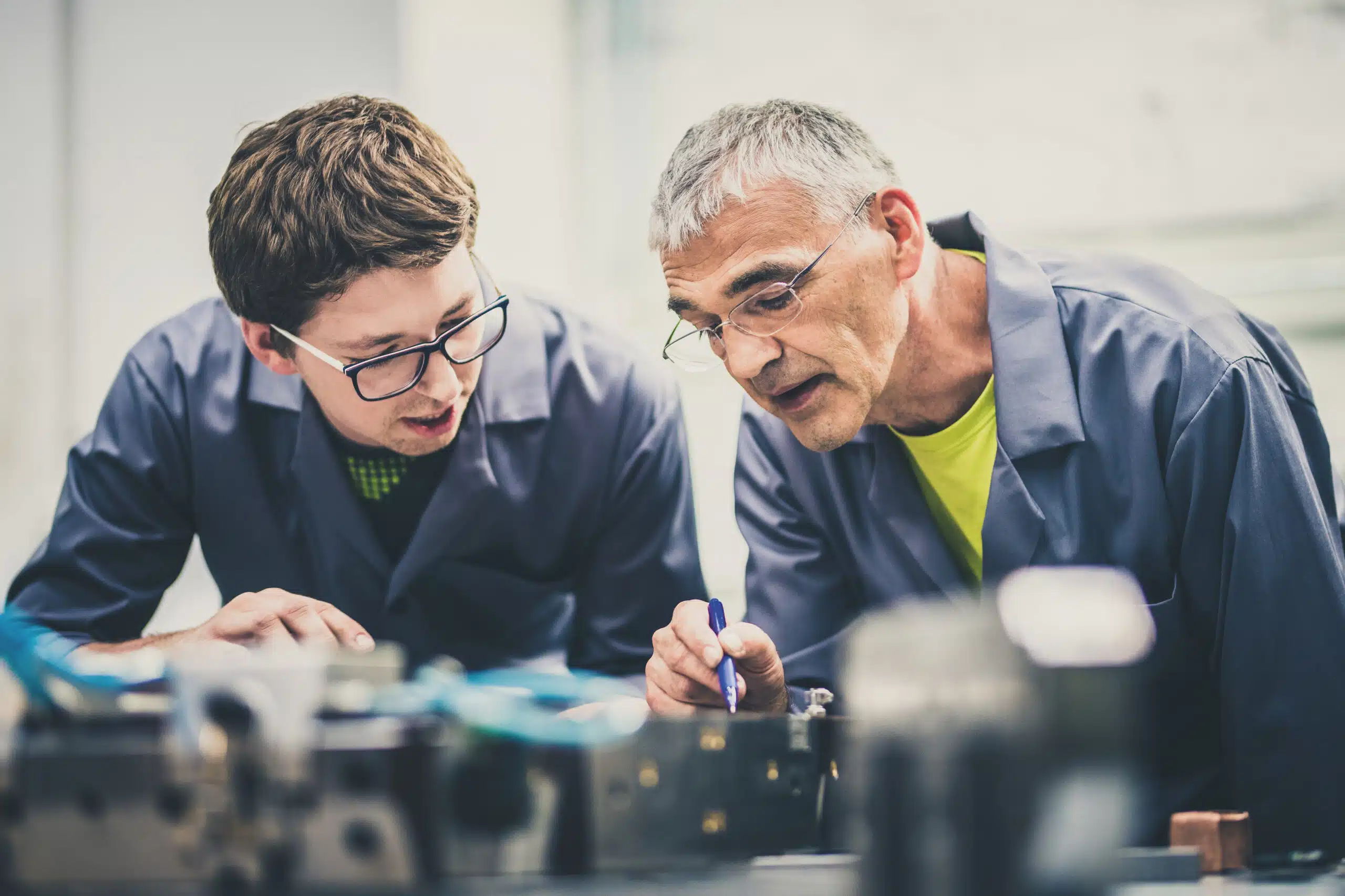 Senior engineer explaining machine functioning to his student